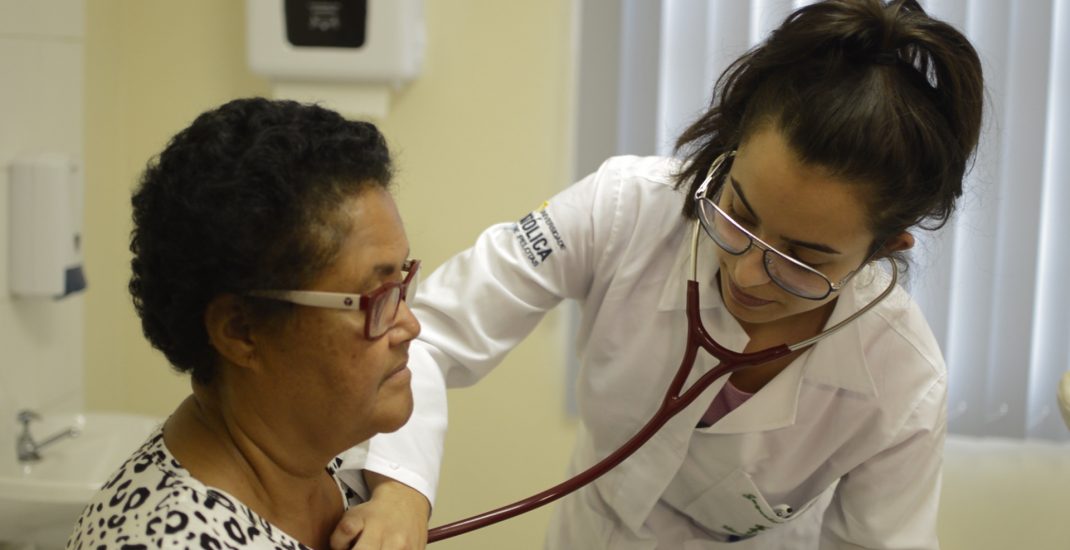 Acadêmica da medicina ausculta sistema circulatório de paciente.